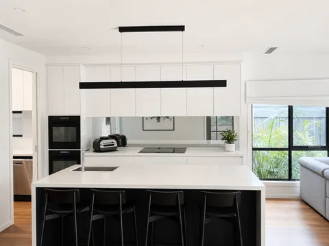 Linear pendant light over a kitchen island in a white Melbourne kitchen
